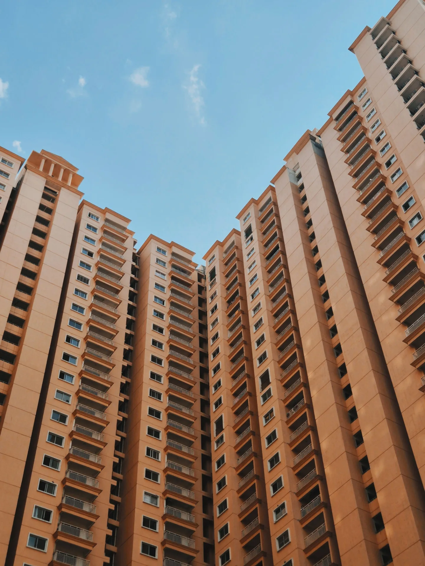 Exterior of multi-story condominium buildings against a blue sky